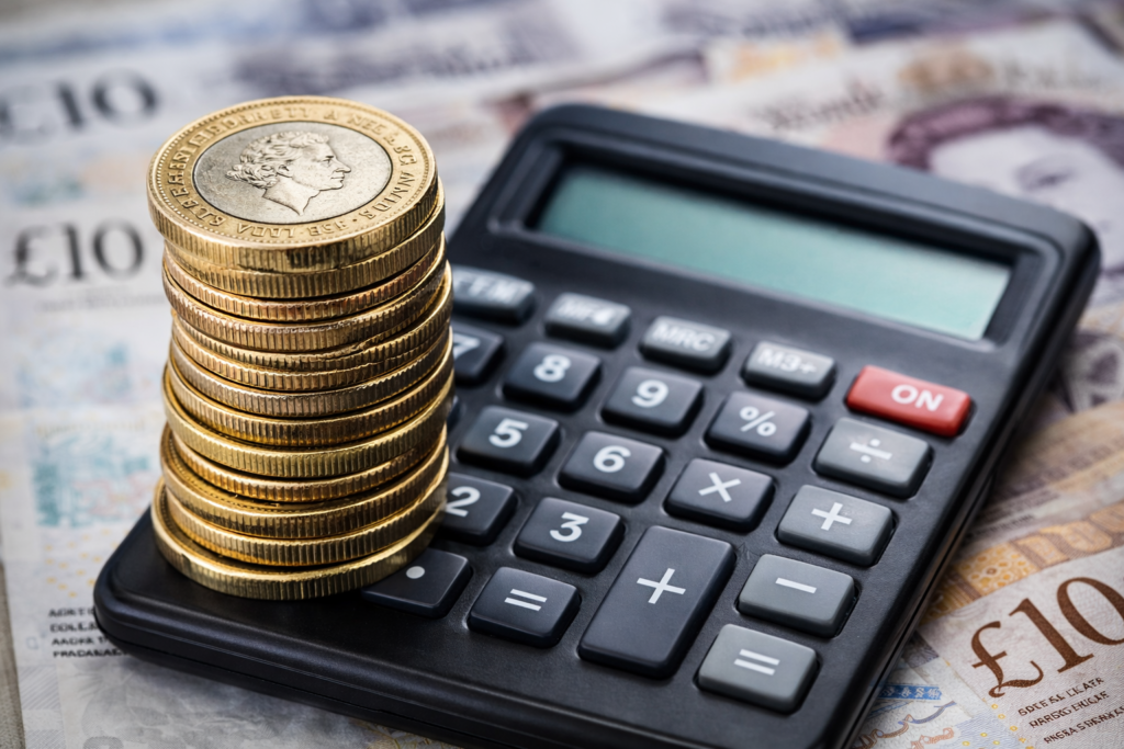 compound interest calculator uk with calculator and British pound coins