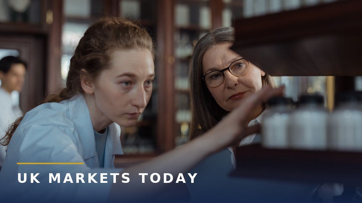 Two pharmacists looking at medicine bottles on a pharmacy shelf