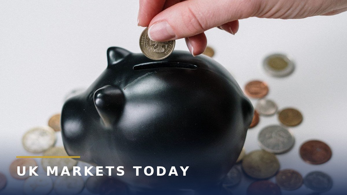Hand putting a coin into a black piggy bank surrounded by coins, the UK Found Money Index