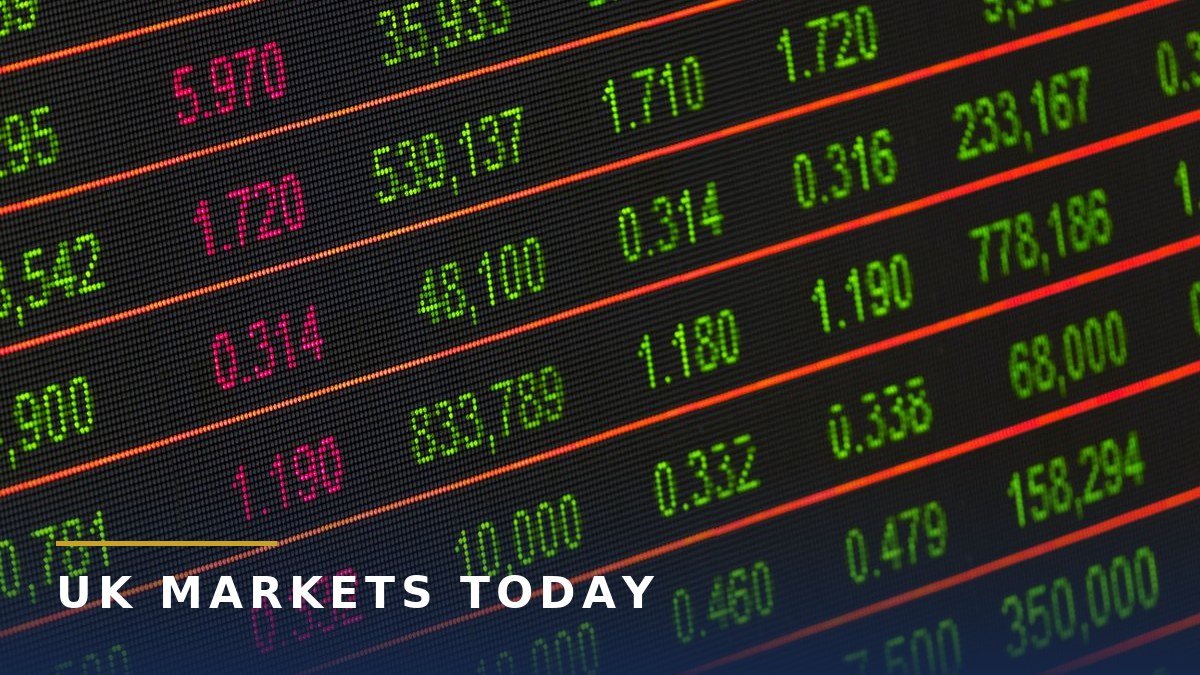 Stock market prices in green and pink numbers on a dark electronic board