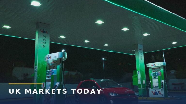 A red car at a petrol station forecourt at night, next to green fuel pumps, for the petrol prices on Google Maps story